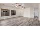 Spacious living room with wood-style flooring, ceiling fans, and natural light through large windows at 1434 W Brangus Way, San Tan Valley, AZ 85143