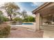 Lush backyard with a swimming pool, patio area, and mature trees, creating a serene outdoor oasis at 14402 N Silverado Dr, Fountain Hills, AZ 85268