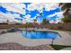 Beautiful backyard with sparkling pool, mature palm trees, and lush landscaping, perfect for relaxing at 14609 W Marcus Dr, Surprise, AZ 85374