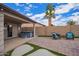 Backyard featuring a covered patio with a hot tub, stone pavers and artificial turf at 14609 W Marcus Dr, Surprise, AZ 85374