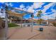 A backyard pergola features cafe lights overlooking a pebble landscape, swimming pool and covered patio at 14609 W Marcus Dr, Surprise, AZ 85374