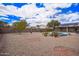 Expansive backyard showcasing desert landscaping, mature trees, and a charming pergola-covered seating area at 14609 W Marcus Dr, Surprise, AZ 85374