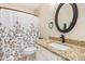 Well-lit bathroom featuring granite countertops, neutral paint, framed mirror and tub with shower curtain at 14609 W Marcus Dr, Surprise, AZ 85374