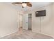 Neutral bedroom showcasing carpet flooring, ceiling fan, wall-mounted TV and walk-in closet at 14609 W Marcus Dr, Surprise, AZ 85374