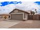 Single-story home with desert landscaping, a two-car garage, paved driveway, and neutral paint at 14609 W Marcus Dr, Surprise, AZ 85374