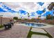 Inviting backyard pool features a rock waterfall, ample seating, and a brick-paved patio perfect for entertaining at 14609 W Marcus Dr, Surprise, AZ 85374