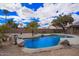 Private pool with rock accents and mature landscaping offers a serene and refreshing outdoor escape at 14609 W Marcus Dr, Surprise, AZ 85374