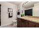 Bright bathroom features a granite countertop, wood cabinet, a decorative mirror, and a shower with black accents at 15050 N Thompson Peak Pkwy # 1006, Scottsdale, AZ 85260