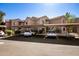 Exterior of a multi-Gathering home with assigned covered parking spots, a well-kept lawn, and garden at 15050 N Thompson Peak Pkwy # 1006, Scottsdale, AZ 85260