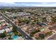 The aerial view shows a vibrant neighborhood with lush trees, community pools, and mountain views at 1509 W Tuckey Ln, Phoenix, AZ 85015