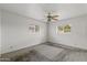 An empty bedroom featuring carpet floors, a ceiling fan, and two bright windows at 1509 W Tuckey Ln, Phoenix, AZ 85015