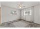 An empty bedroom featuring a ceiling fan, carpet floors, and windows with curtains at 1509 W Tuckey Ln, Phoenix, AZ 85015