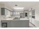 Bright kitchen features stainless steel appliances, gray and white cabinets, island with cooktop, and skylight at 1509 W Tuckey Ln, Phoenix, AZ 85015