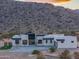 Sleek desert home set against a mountain backdrop, featuring contemporary architecture blending seamlessly with the natural environment at 15574 N Brielles Way, Maricopa, AZ 85139