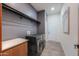 Modern laundry room features sleek black washer and dryer with gray walls and ample lighting at 15574 N Brielles Way, Maricopa, AZ 85139