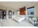 Spacious bedroom featuring a cozy bed, wood accent wall, neutral tones, and large windows for ample natural light at 15574 N Brielles Way, Maricopa, AZ 85139