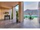 Covered patio with outdoor dining and desert views, complemented by decorative greenery and ambient string lights at 15574 N Brielles Way, Maricopa, AZ 85139