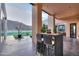 Inviting covered patio featuring a dining set, showcasing outdoor living and desert views with mountain backdrop at 15574 N Brielles Way, Maricopa, AZ 85139