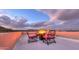 Evening view of the open rooftop terrace with four chairs around a fire pit at 15574 N Brielles Way, Maricopa, AZ 85139