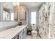 Bathroom featuring floral shower curtain, toilet, and vanity with framed mirror and cabinet at 17200 W Bell Rd # 866, Surprise, AZ 85374