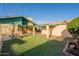 Charming backyard featuring a covered patio, green lawn, and well-maintained landscaping for outdoor enjoyment at 1721 W Weldon Ave, Phoenix, AZ 85015