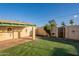 A covered patio and a well-maintained lawn create a welcoming backyard space, perfect for relaxation and entertaining at 1721 W Weldon Ave, Phoenix, AZ 85015