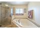 Bright bathroom with a glass enclosed walk-in shower and a soaking tub with tiled surround at 1721 W Weldon Ave, Phoenix, AZ 85015