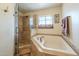 Bathroom featuring glass enclosed walk-in shower and a soaking tub with tile surround at 1721 W Weldon Ave, Phoenix, AZ 85015