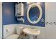 Stylish bathroom with a blue accent wall, an oval mirror, and white fixtures for a clean look at 1721 W Weldon Ave, Phoenix, AZ 85015