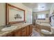 A spacious bathroom features dual sinks with granite countertops, a soaking tub, and a walk-in shower at 1721 W Weldon Ave, Phoenix, AZ 85015