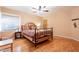 Warm bedroom featuring a decorative bed frame, a window with blinds, and hardwood flooring at 1721 W Weldon Ave, Phoenix, AZ 85015