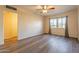 The bedroom has wood-look floors, a ceiling fan, neutral walls, and bright windows at 1721 W Weldon Ave, Phoenix, AZ 85015