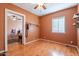 Cozy bedroom featuring hardwood floors, a ceiling fan, and natural light from a bright window at 1721 W Weldon Ave, Phoenix, AZ 85015