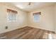 Inviting bedroom with neutral walls, wood-look floors, and windows dressed with patterned valances at 1721 W Weldon Ave, Phoenix, AZ 85015