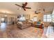 Open-concept living room with an area that opens to the kitchen featuring ceiling fans and wood flooring at 1721 W Weldon Ave, Phoenix, AZ 85015