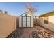 Backyard shed with concrete tile access and decorative rock landscape at 1721 W Weldon Ave, Phoenix, AZ 85015