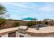 Outdoor kitchen features a built-in grill, bar seating, and lush tropical landscaping, creating a perfect space for entertaining at 17751 W Desert View Ln, Goodyear, AZ 85338