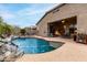 Inviting backyard showcases a sparkling pool with waterfall, adjacent patio dining and lounge area, ideal for outdoor living at 17751 W Desert View Ln, Goodyear, AZ 85338