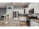 Bright kitchen featuring stainless steel appliances, granite counters, and white cabinetry at 17751 W Desert View Ln, Goodyear, AZ 85338