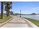 Scenic paved path along the lake's edge, framed by stately palm trees and decorative lamp posts at 17751 W Desert View Ln, Goodyear, AZ 85338