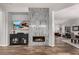 Open living room featuring a modern fireplace, tiled accent wall, and wood-look floors at 17751 W Desert View Ln, Goodyear, AZ 85338