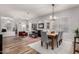 Bright and open-concept living room with wood floors, stylish furniture, and a view into the dining area at 17751 W Desert View Ln, Goodyear, AZ 85338