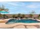 Inviting pool area with a rock waterfall, lush greenery, and comfortable lounge chairs at 17751 W Desert View Ln, Goodyear, AZ 85338