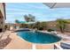 Beautiful pool area featuring a rock waterfall, palm trees and built in bar with seating at 17751 W Desert View Ln, Goodyear, AZ 85338