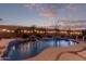 Inviting backyard with a pool, waterfall feature, string lights and poolside seating at 17751 W Desert View Ln, Goodyear, AZ 85338