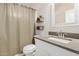 Compact bathroom featuring white vanity with gray countertop, modern fixtures, and a shower with neutral curtain at 1841 E Clarendon Ave, Phoenix, AZ 85016