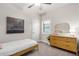 Bright bedroom with neutral decor featuring a sleek wood dresser with decor, a twin bed, and shuttered window at 1841 E Clarendon Ave, Phoenix, AZ 85016