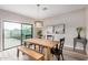 Sunlit dining area features a wooden table and bench set, stylish chandelier, and sliding glass doors for easy access to outdoors at 1841 E Clarendon Ave, Phoenix, AZ 85016