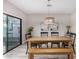 Inviting dining room with wood table, black chairs, and modern light fixture, illuminated by natural light from sliding door at 1841 E Clarendon Ave, Phoenix, AZ 85016