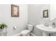 Cozy half bathroom features a pedestal sink, round mirror, and decorative accents at 18938 W Luke Ave, Litchfield Park, AZ 85340